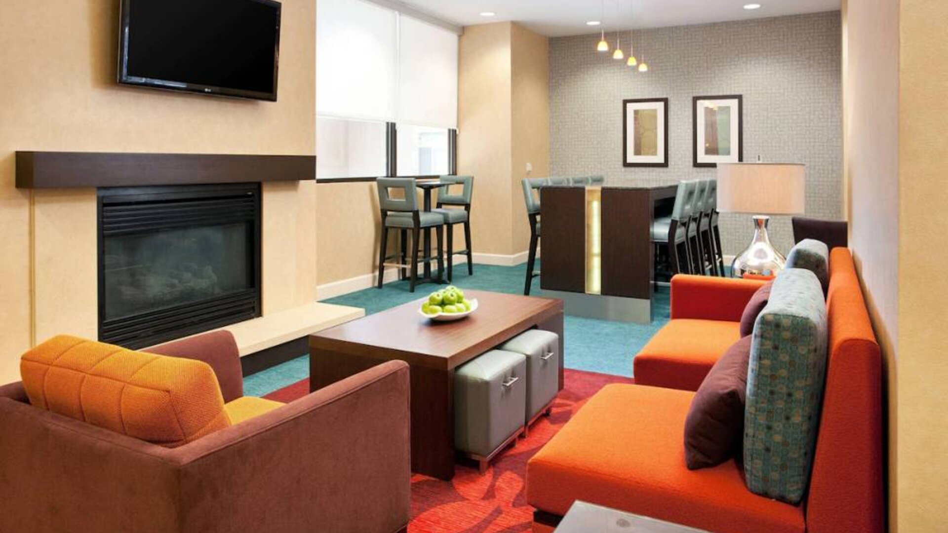 Sonesta ES Suites San Antonio Downtown Alamo Plaza’s lobby lounge has comfy seating, a fireplace, and a wall-mounted TV.