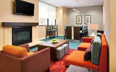 Sonesta ES Suites San Antonio Downtown Alamo Plaza’s lobby lounge has comfy seating, a fireplace, and a wall-mounted TV.