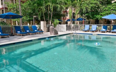 Large outdoor pool with sun lounge chairs at Sonesta ES Suites Fort Lauderdale Plantation.