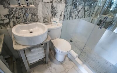 Guest bathroom with shower at Chesterfield Hotel & Suites.