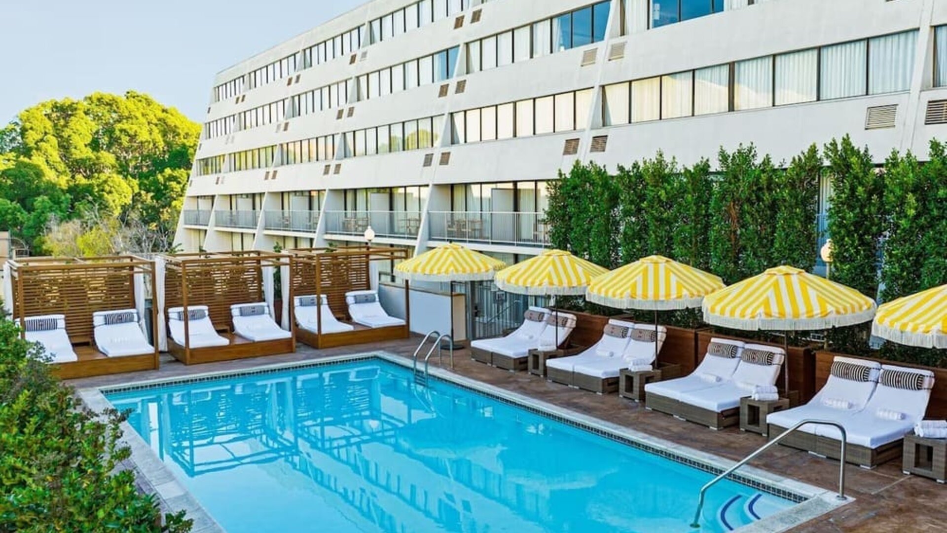 Relaxing outdoor pool with pool loungers at Hotel Dena, Pasadena Los Angeles.