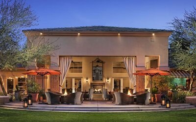 Hotel exterior with outdoor seating at Sonesta Suites Scottsdale Gainey Ranch.