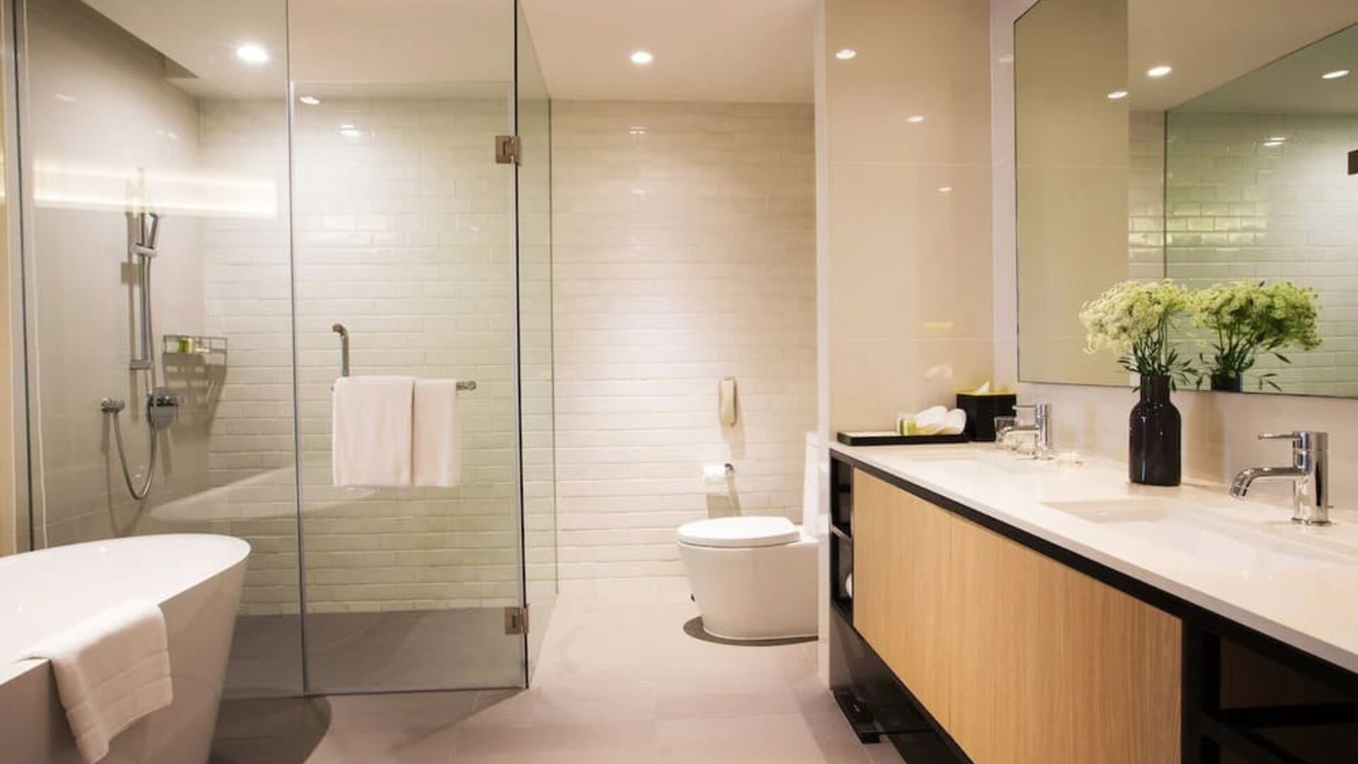 Guest bathroom with bath and shower at Modena By Fraser Bangkok.