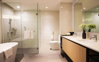 Guest bathroom with bath and shower at Modena By Fraser Bangkok.