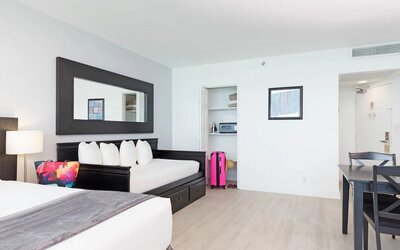Day room with king bed and lounge chair at New Point Miami.