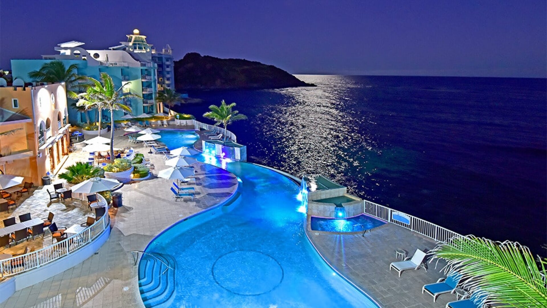 Aerial nighttime angle of lit up Infinity Pool at Oyster Bay Resort in St. Maarten.
