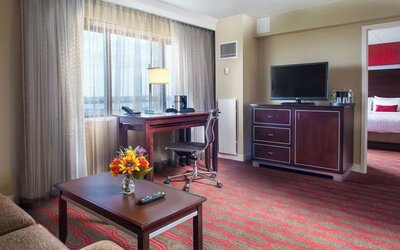 Spacious king room with lounge area at Laguardia Plaza Hotel.