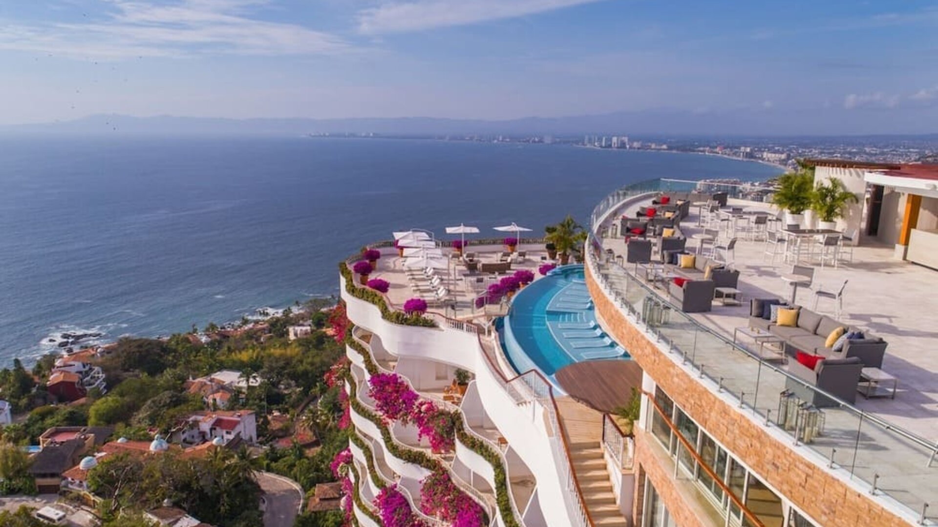 Hotel exterior with pool and ocean view at Grand Miramar All Luxury Suites & Residences.