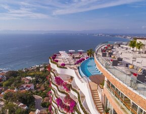Hotel exterior with pool and ocean view at Grand Miramar All Luxury Suites & Residences.
