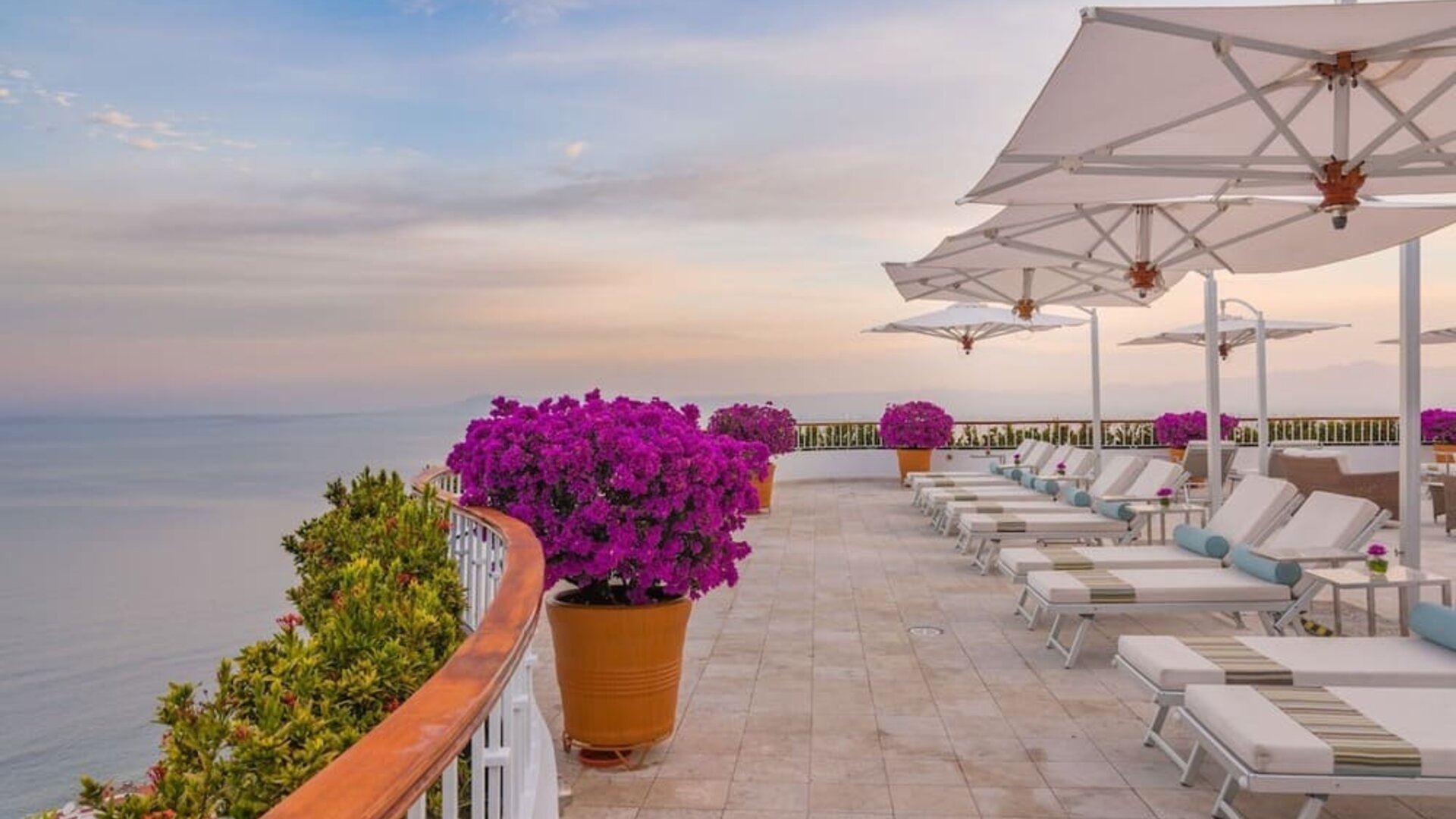 Outdoor terrace with pool chairs at Grand Miramar All Luxury Suites & Residences.