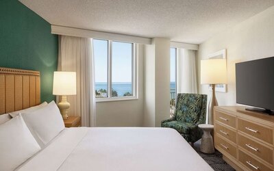 Romantic king room with TV at Embassy Suites By Hilton Deerfield Beach Resort & Spa.