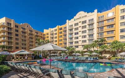 Stunning outdoor pool with loungers and umbrellas at Embassy Suites By Hilton Deerfield Beach Resort & Spa.