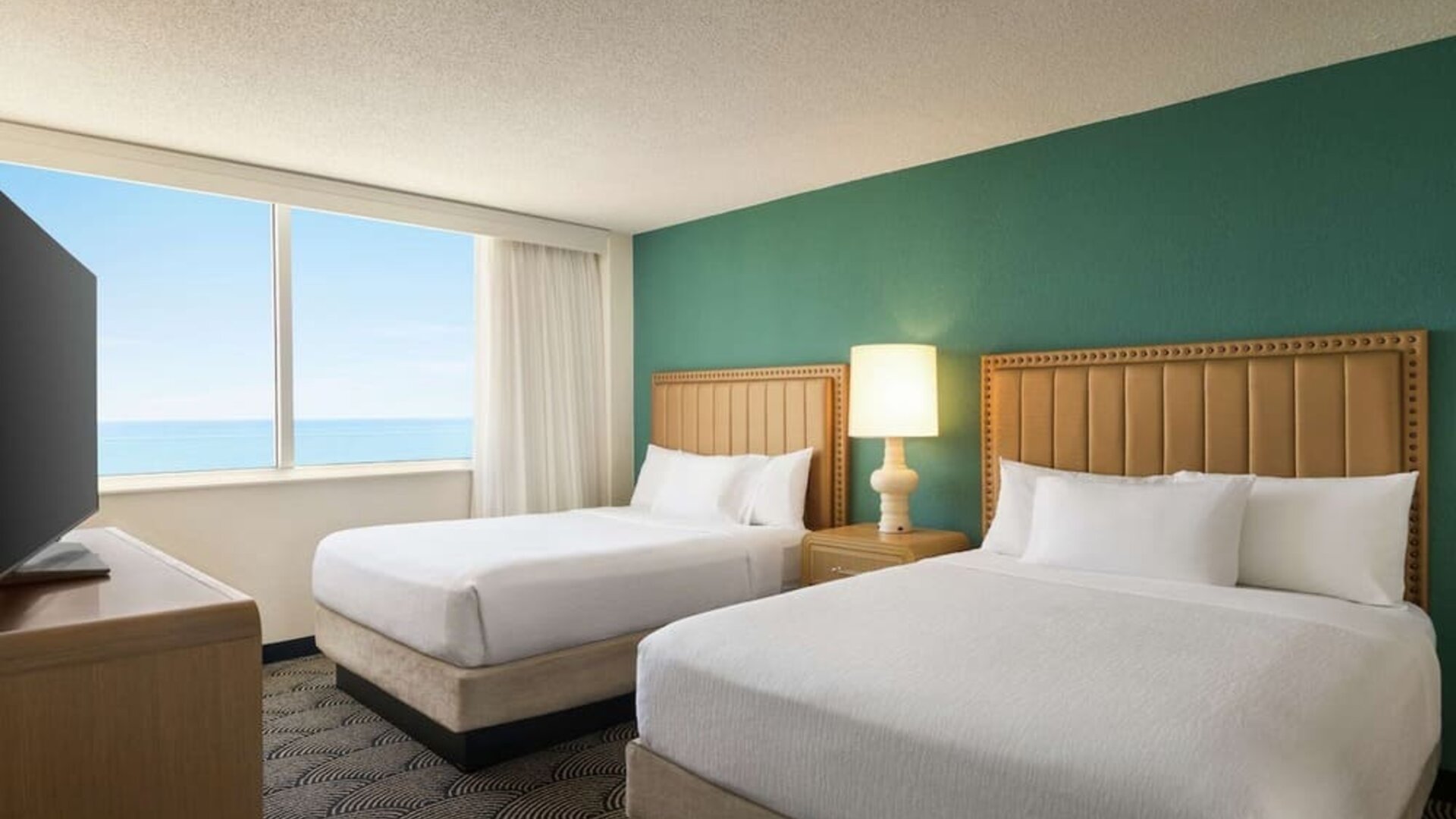 Two queen beds with TV and ocean view at Embassy Suites By Hilton Deerfield Beach Resort & Spa.
