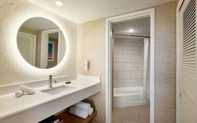 Guest bathroom with shower at Embassy Suites By Hilton Deerfield Beach Resort & Spa.