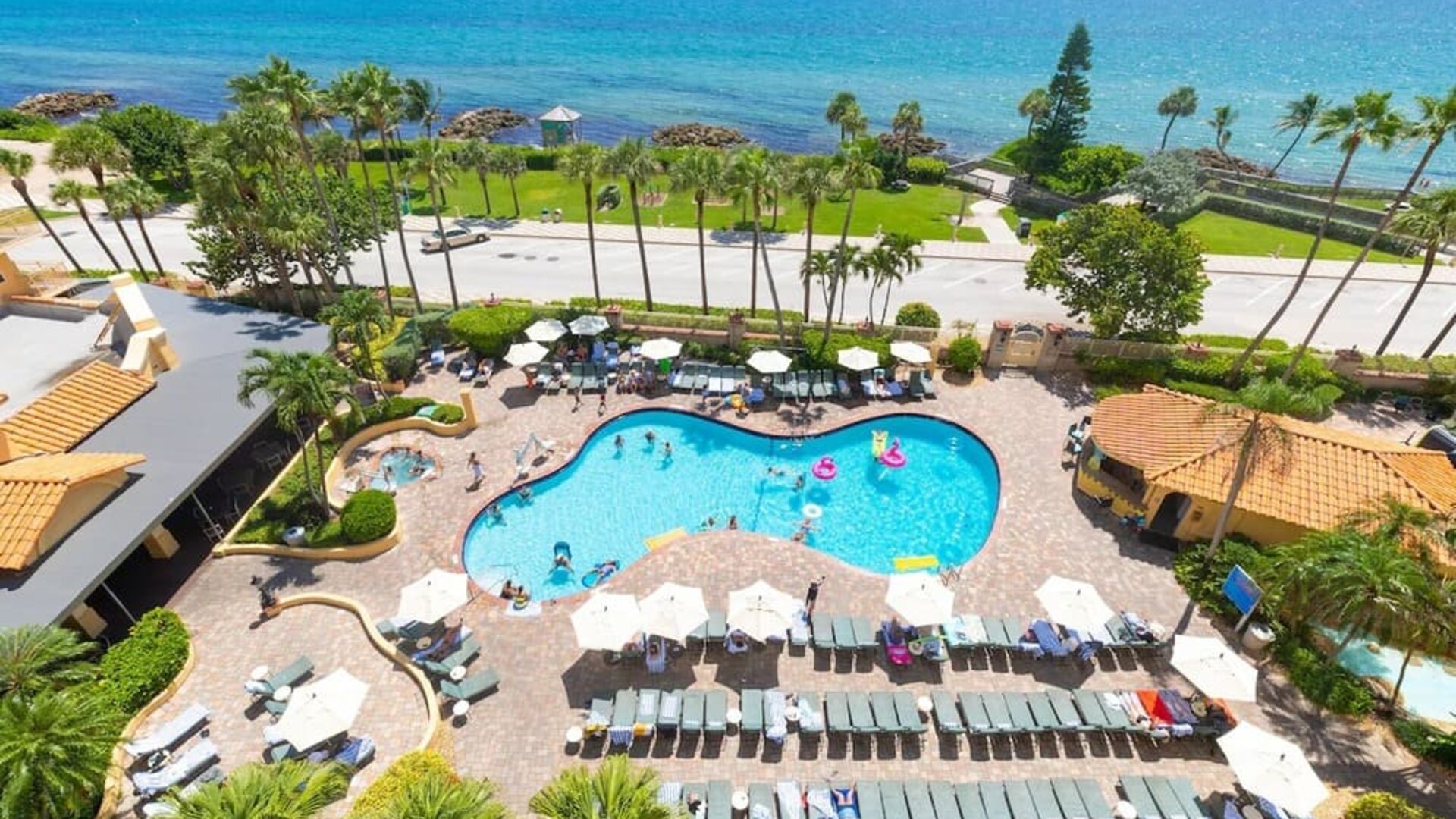 Outdoor pool with loungers at Embassy Suites By Hilton Deerfield Beach Resort & Spa.