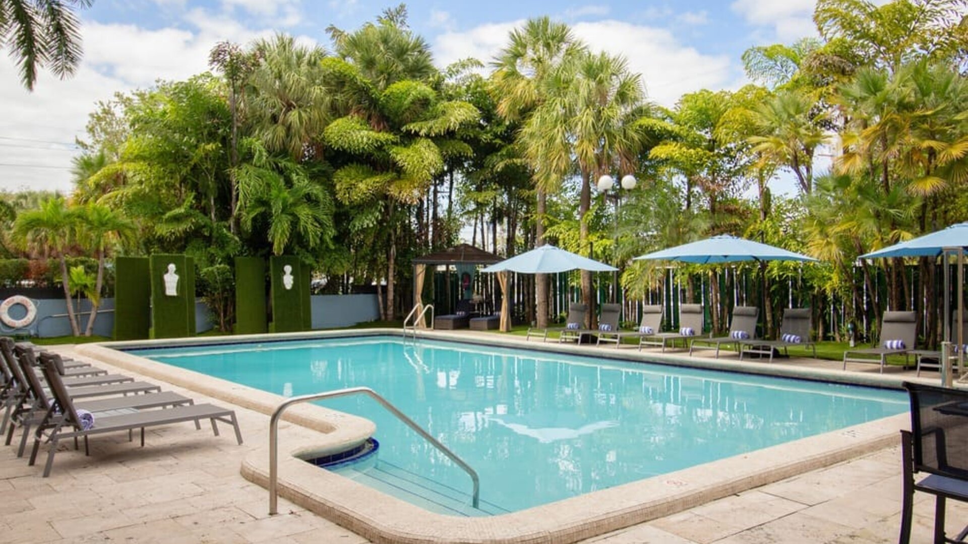 Outdoor pool with trees at Regency Miami Airport By Sonesta.