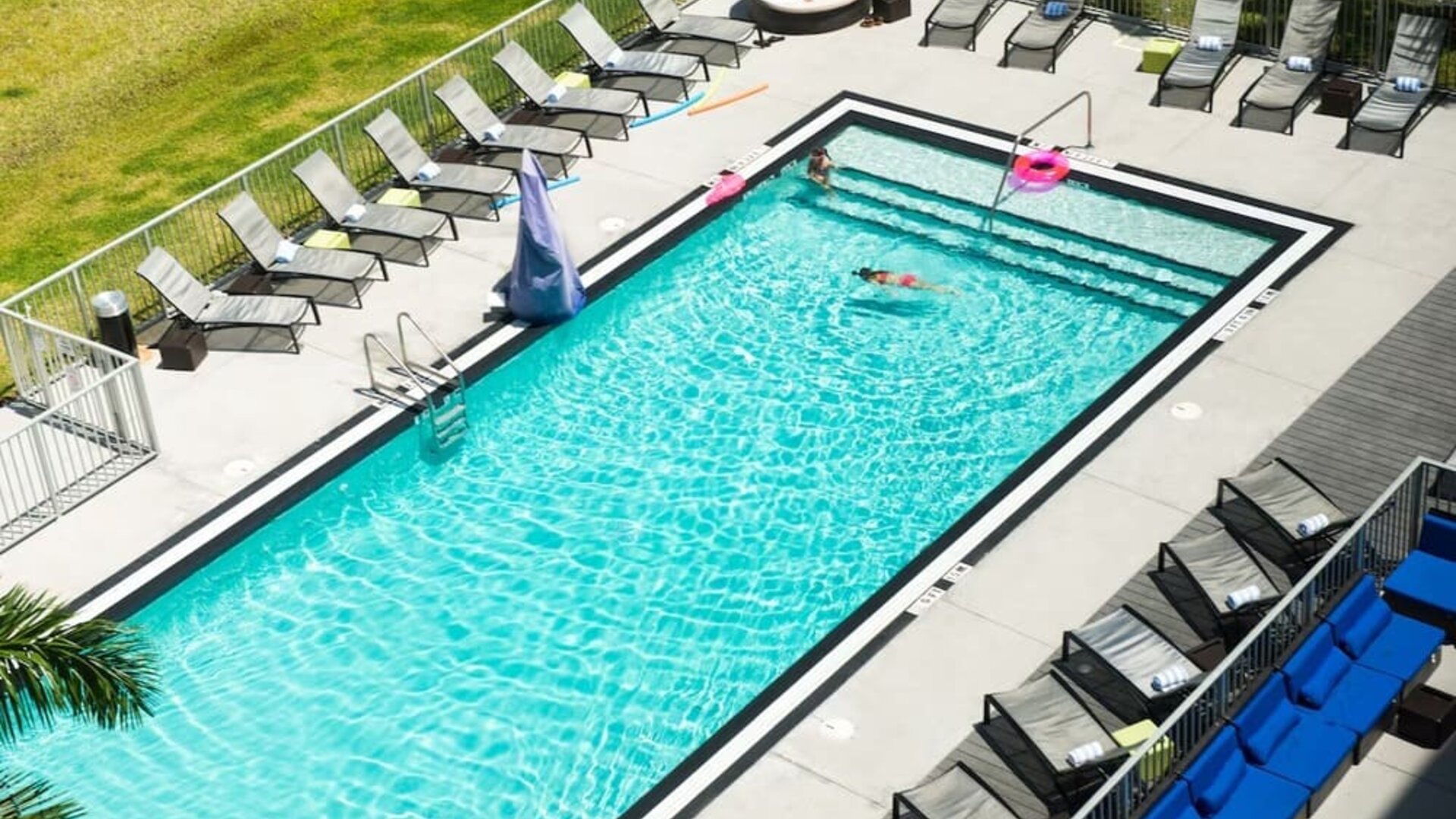 Outdoor pool with loungers at Aloft Miami Doral.
