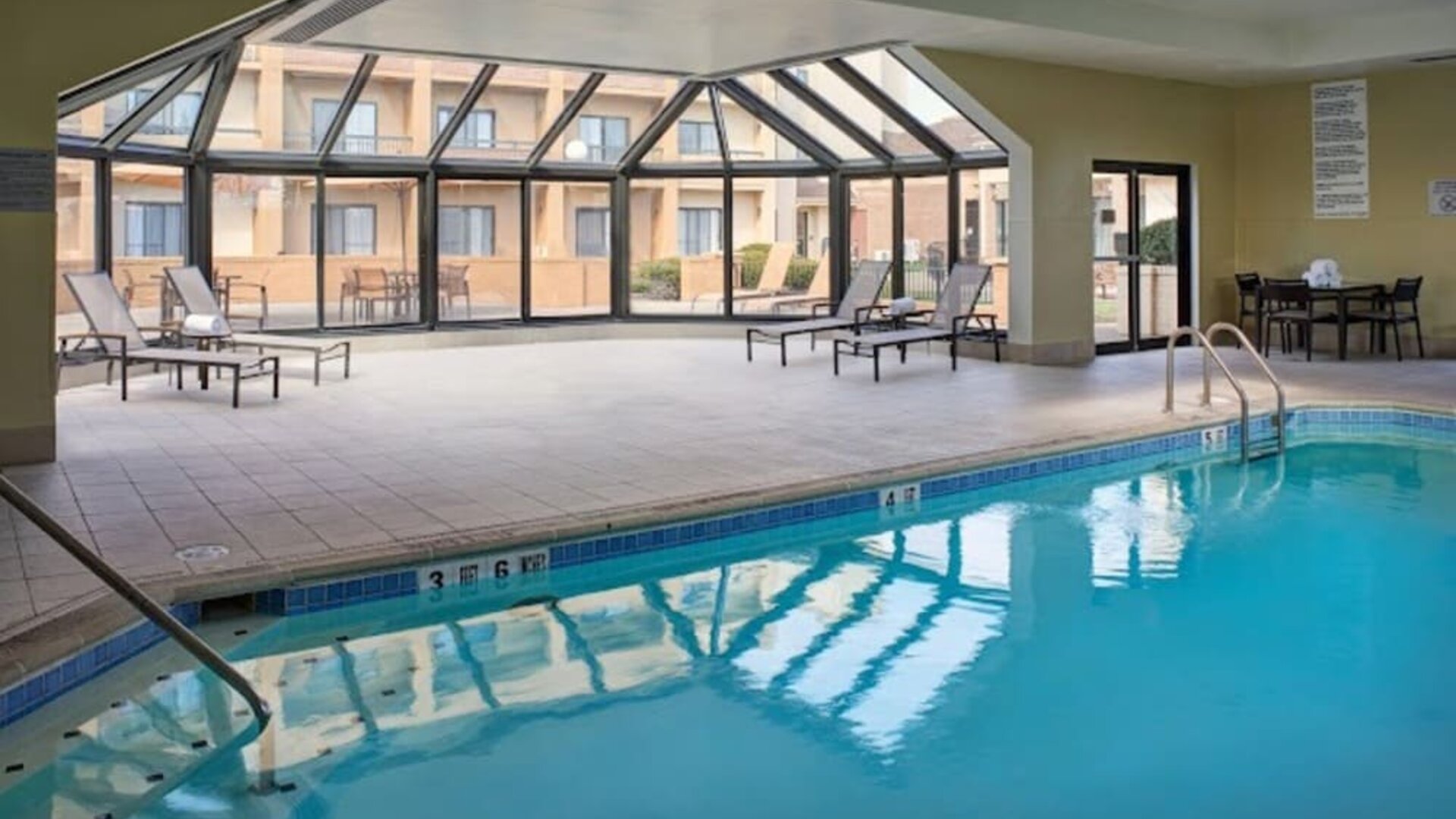 Sonesta Select Indianapolis Carmel’s indoor pool has loungers and chairs nearby.