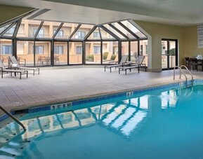 Sonesta Select Indianapolis Carmel’s indoor pool has loungers and chairs nearby.