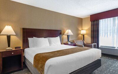 King room featuring premium bedding, bedside lighting, and a relaxing seating area at Best Western Braintree.