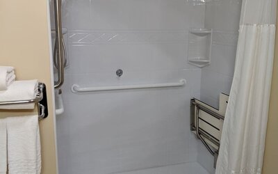 Accessible roll-in shower featuring safety grab bars, spacious layout, and mobility-friendly amenities at Best Western Braintree.