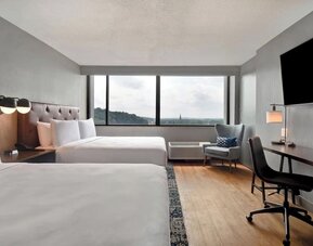 Double queen guest room featuring spacious accommodations, work desk, and scenic views for families, groups, or business travelers at Four Points by Sheraton Boston-Newton.