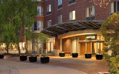 Welcoming hotel entrance featuring covered access, landscaped surroundings, and convenient arrival accommodations at Courtyard by Marriott Boston Brookline.