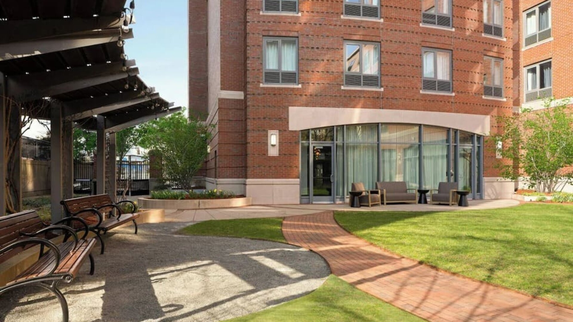 Outdoor courtyard space with landscaped gardens, comfortable seating, and a relaxing atmosphere for guests at Courtyard by Marriott Boston Brookline.