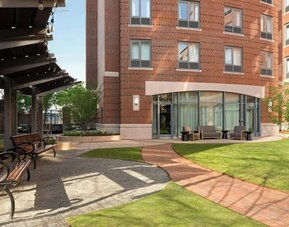 Outdoor courtyard space with landscaped gardens, comfortable seating, and a relaxing atmosphere for guests at Courtyard by Marriott Boston Brookline.