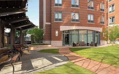 Outdoor courtyard space with landscaped gardens, comfortable seating, and a relaxing atmosphere for guests at Courtyard by Marriott Boston Brookline.