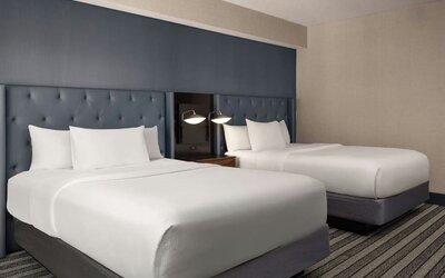 Double queen guest room featuring premium bedding, stylish furnishings, and comfortable accommodations for leisure or business travelers at Courtyard by Marriott Boston Brookline.