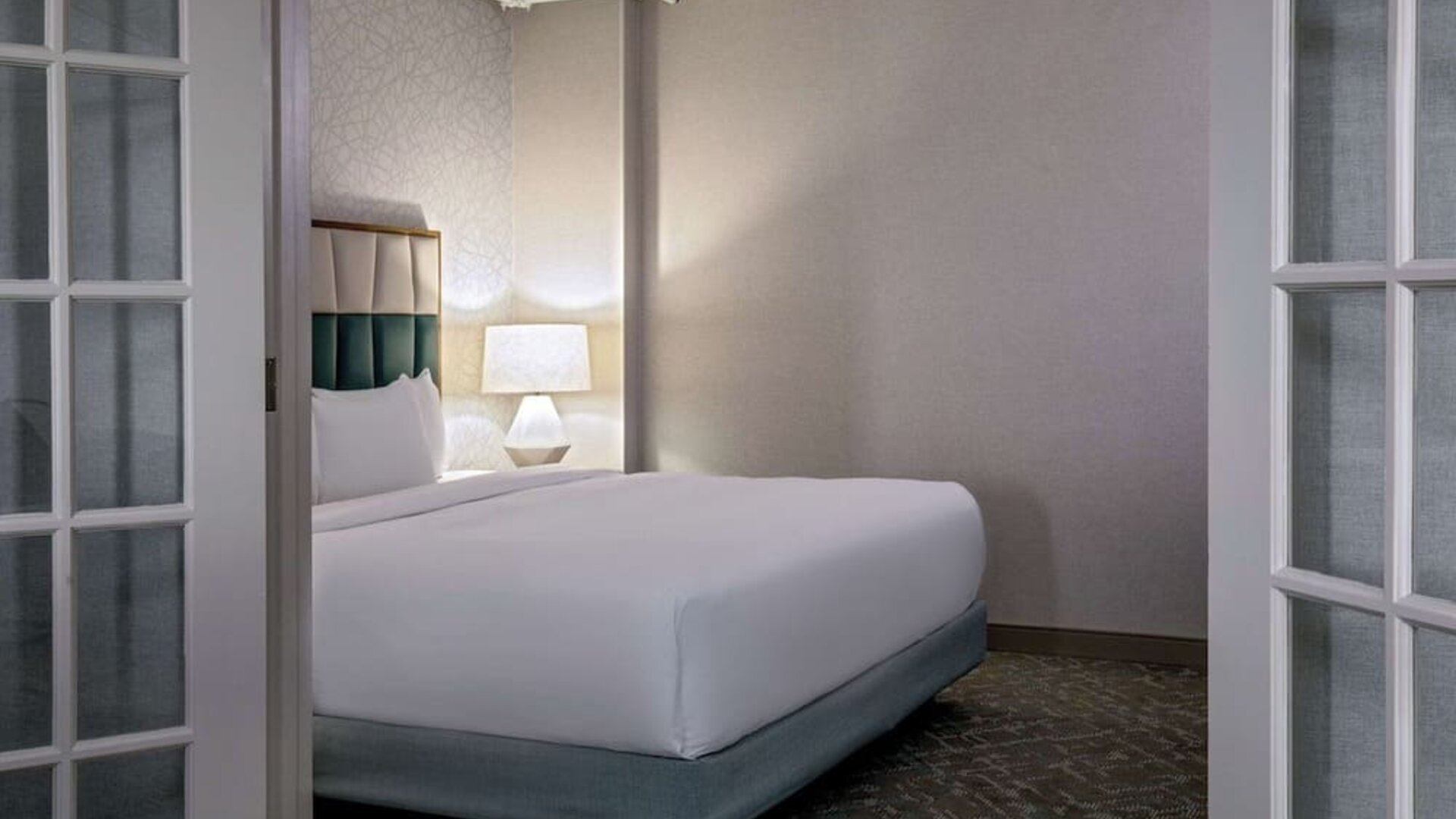 Private bedroom within a suite offering plush bedding, elegant furnishings, and a peaceful retreat for relaxation at DoubleTree by Hilton Westborough.