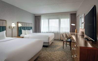 Double queen guest room featuring premium bedding, a dedicated workspace, and comfortable accommodations for business and leisure travelers at DoubleTree by Hilton Westborough.