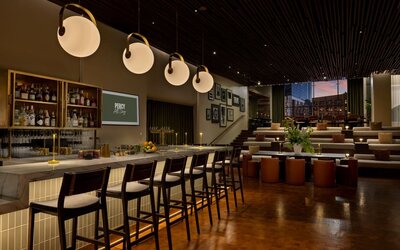 Stylish bar area offering handcrafted cocktails, modern seating, and a vibrant social atmosphere in the heart of Row NYC.