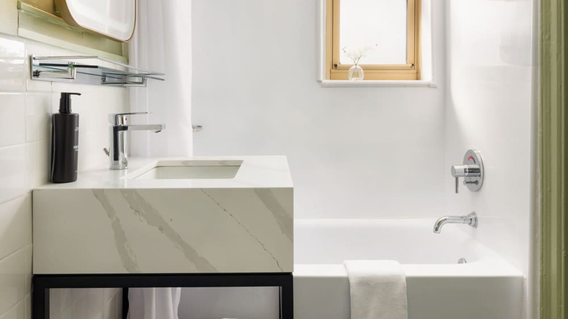 Guest bathroom featuring a spacious bathtub, modern vanity, and clean contemporary décor designed for comfort at Row NYC.