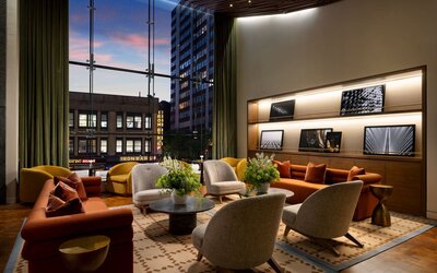 Sophisticated lobby lounge featuring floor-to-ceiling windows, contemporary furnishings, and comfortable gathering spaces at Row NYC.