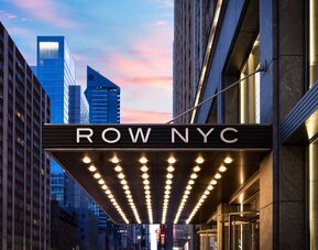 Entrance canopy of Row NYC illuminated with signature lighting, creating a memorable arrival experience in Times Square.