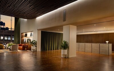 Spacious hotel reception area featuring modern design, streamlined check-in services, and a welcoming atmosphere for arriving guests at Row NYC.