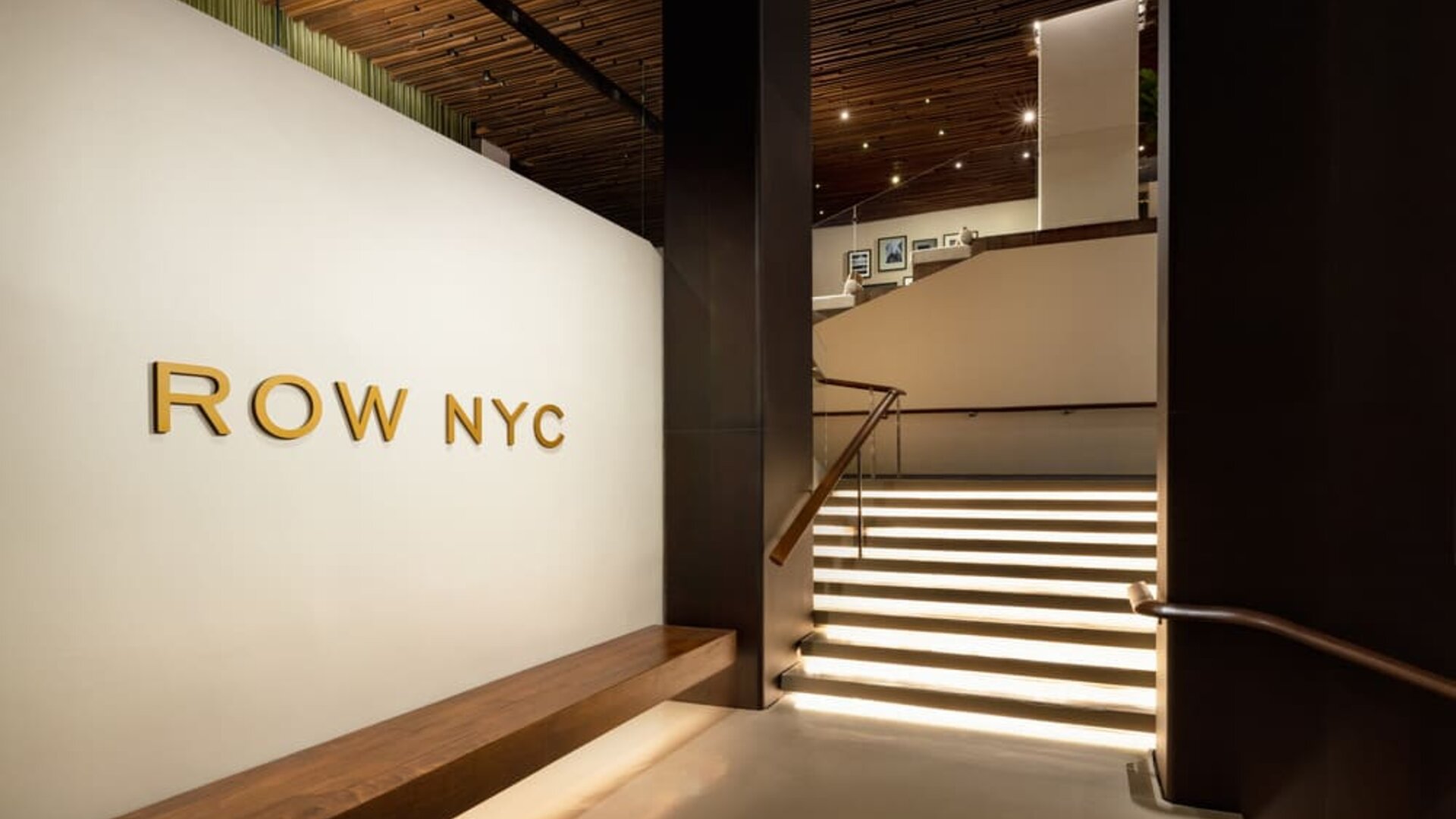 Grand staircase and lobby entrance featuring elegant lighting, contemporary architecture, and stylish design elements at Row NYC.