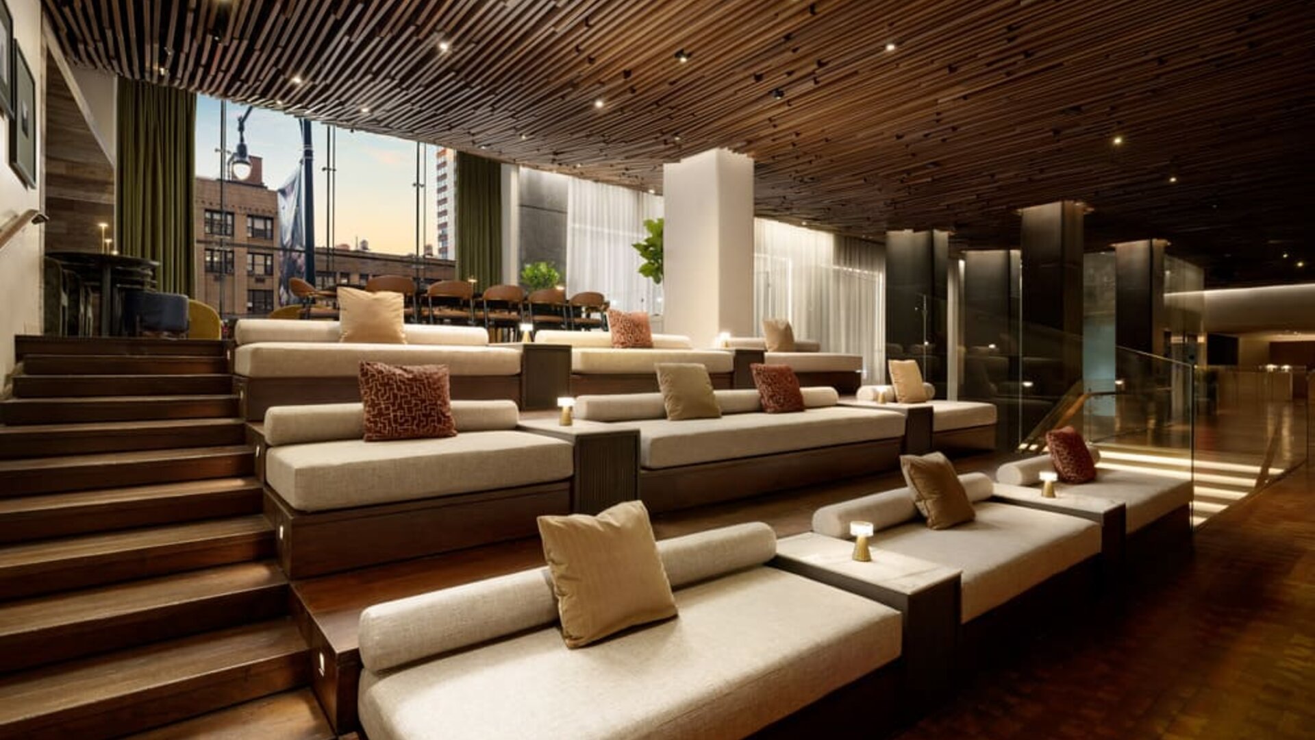 Tiered lounge seating area featuring modern furnishings, warm lighting, and inviting communal spaces for guests to relax and socialize at Row NYC.