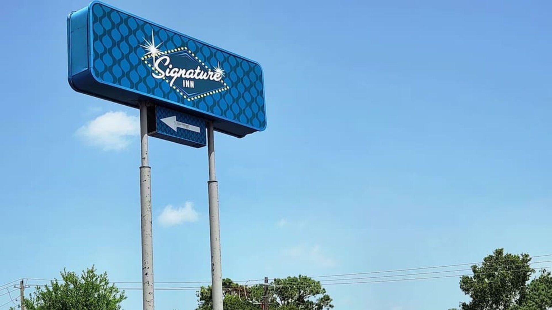 Hotel exterior and sign board at Signature Inn Houston Galleria.