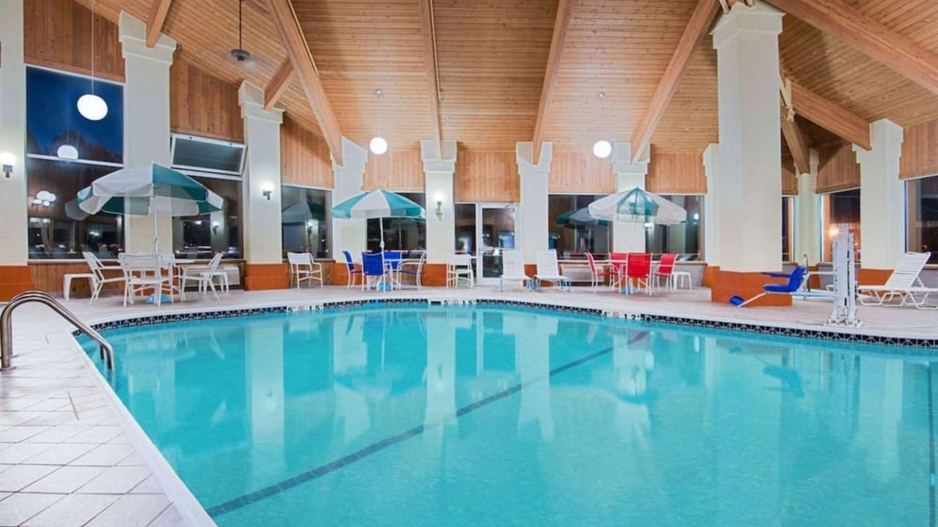 Indoor pool with seating area at Baymont By Wyndham Pella.