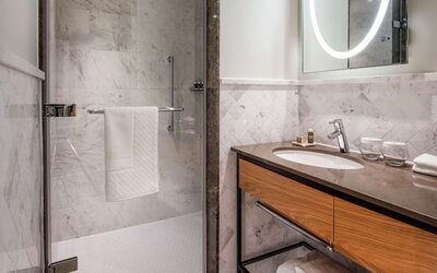 Guest bathroom with shower at Lincoln Plaza London, Curio Collection By Hilton.