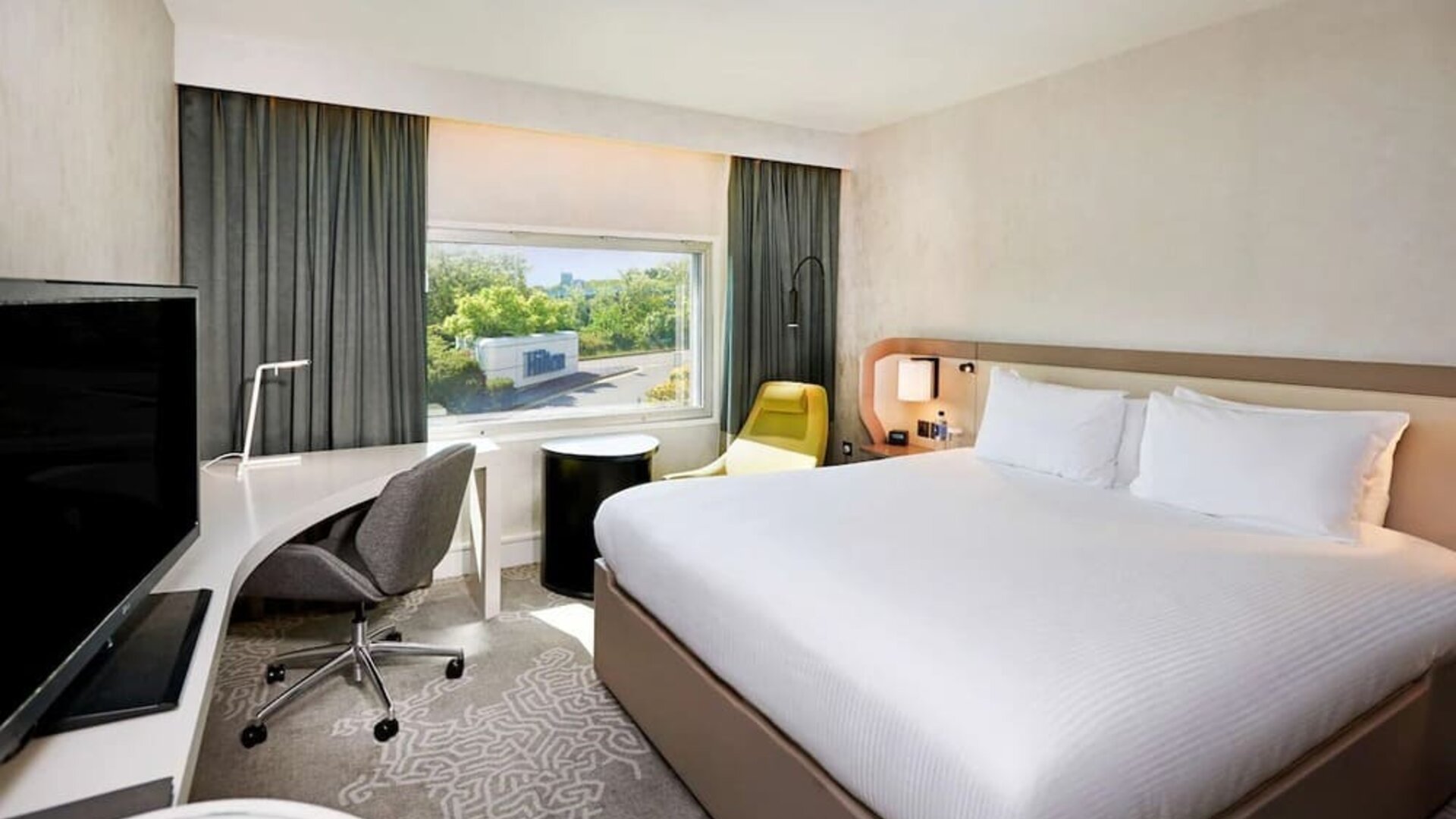 King bedroom with work desk at Hilton London Heathrow Airport.