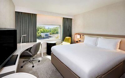 King bedroom with work desk at Hilton London Heathrow Airport.