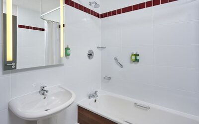 Guest bathroom with shower and tub at Leonardo Hotel Milton Keynes.