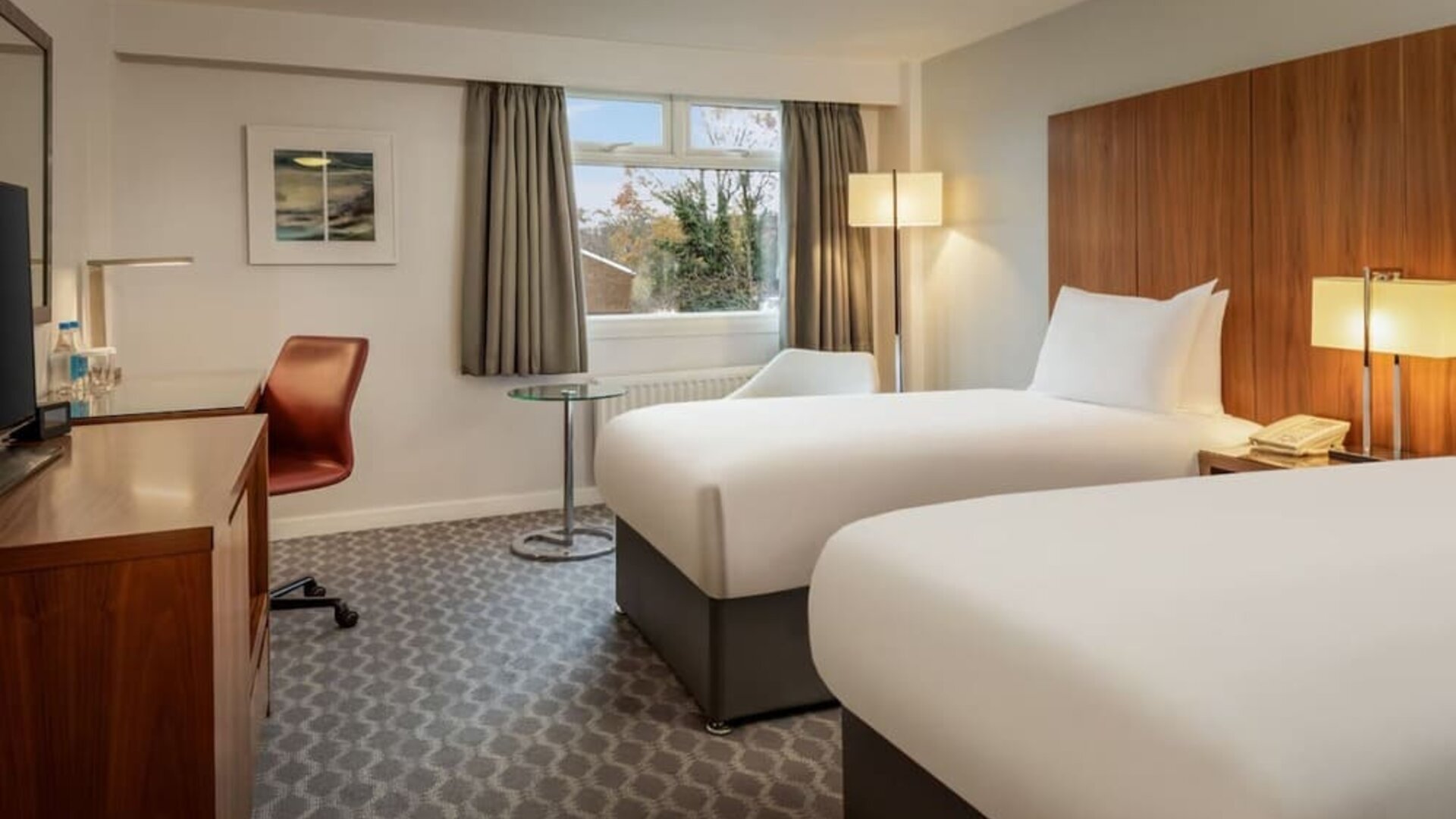 Day use room with double bed, work desk and TV at Hilton London Watford.