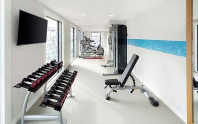 Bright fitness center with machines and equipment at the Hampton by Hilton London Docklands.