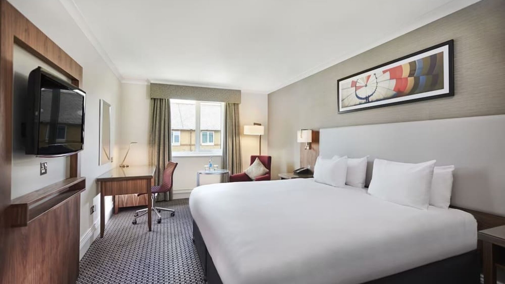 King bedroom with TV screen and desk at the DoubleTree by Hilton Bristol North.