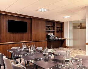 Professional meeting room with TV screen and coffee maker at the Hilton Birmingham Metropole.